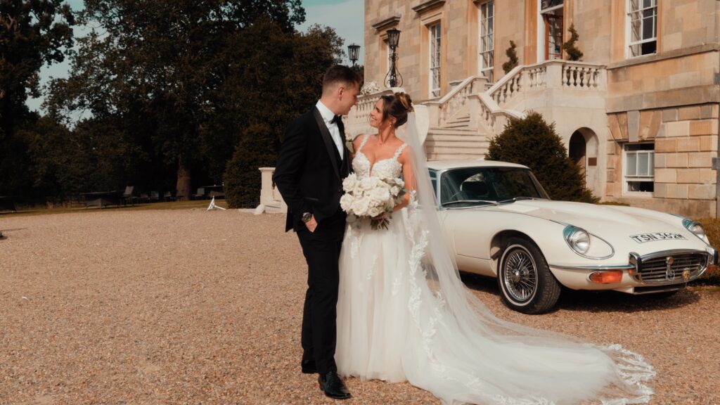 A couple are all smiles on their wedding day, showing that you don't need to be afraid of wedding videography and can just have fun with it!