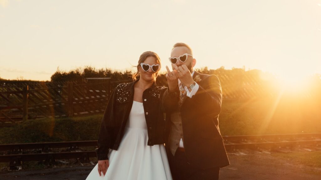 Cool AF bride and groom celebrate during a glorious golden hour on their wedding day. Captured by cool wedding videographer based in the UK, HC Visuals.