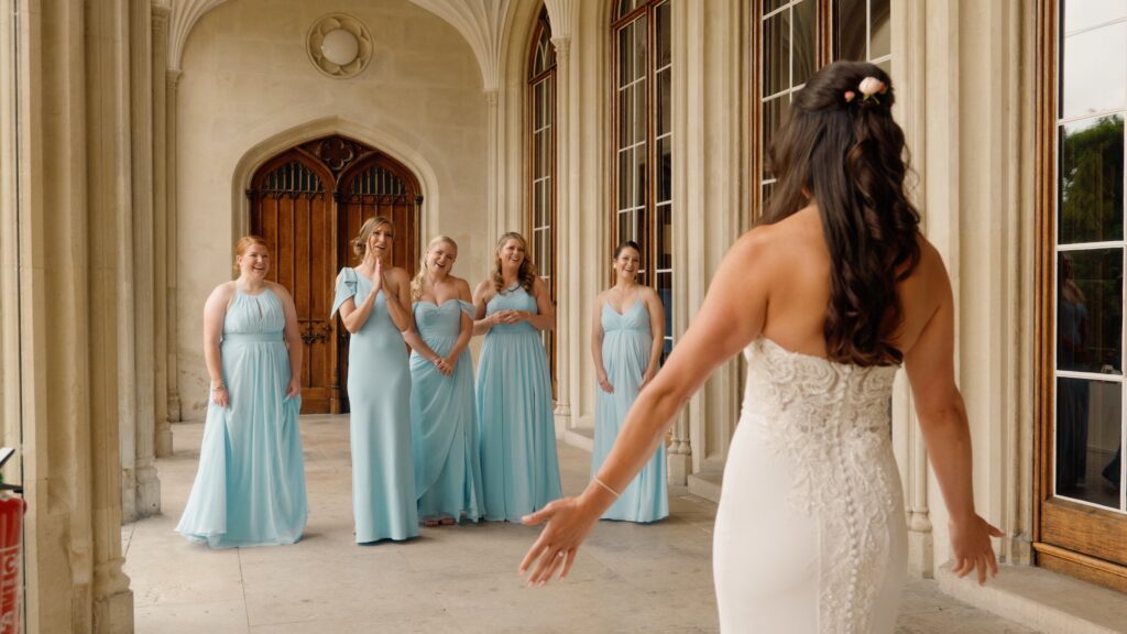 Bride does a dress reveal with her bridesmaids crew on her wedding day. Captured on film by wedding videographer HC Visuals.