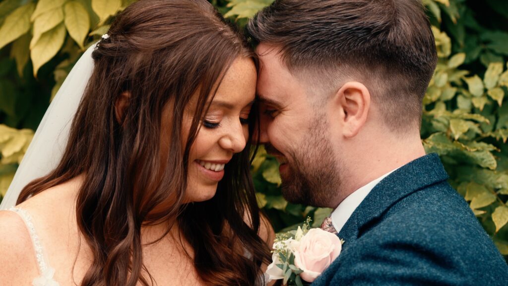 Couple share a tender moment on their wedding day. Captured by wedding videographer HC Visuals.